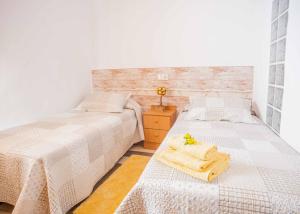 1 dormitorio con 2 camas y toallas. en Casa Rural Marila, en Puigmoreno