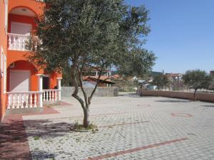 a tree in the middle of a brick road next to a building at Apartments Sor - on the beach in Bibinje