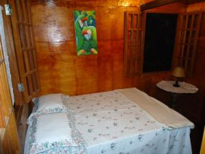Cama en habitación con pared de madera en Casa na Árvore, en Salvador