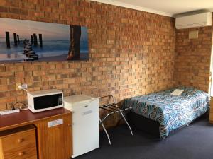 a bedroom with a bed and a tv at Kadina Gateway Motor Inn in Kadina