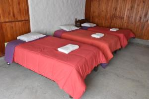 2 camas en una habitación con sábanas rojas en Oasis Paraiso Ecolodge, en Cabanaconde