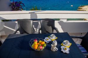 a blue table with a bowl of fruit and hats on it at Apartments Bisernica-with pool in Ražanj