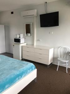 a hotel room with a bed and a television at Ettalong Beach motel in Ettalong Beach