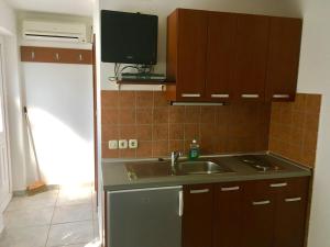 a kitchen with a sink and a tv on the wall at Apartments Suzana in Jakišnica