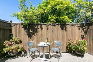 een patio met een tafel en stoelen voor een hek bij Fairley Motor Lodge in Napier