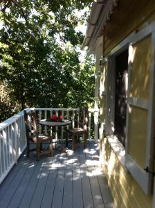 a porch with a table and chairs on a house at Treehouse Cottage in Five Islands Village