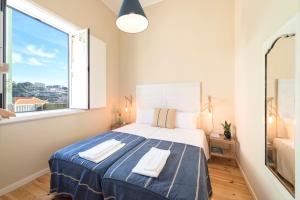 a bedroom with a large bed with two towels on it at Porto D'Ouro Apartment in Porto