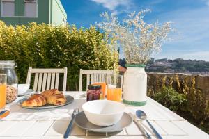 a table with a plate of food and a vase of flowers at Porto D'Ouro Apartment in Porto