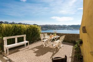 a table and chairs on a patio with a view of the water at Porto D'Ouro Apartment in Porto