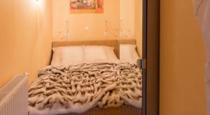 シャルボイツにあるAltes Strandhus Kl.App Casa Ostseeの毛布付きの小さな部屋のベッド1台分です。