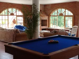 a pool table in a living room with windows at La Casa del Rio B&B in Puyo