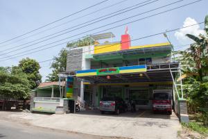 a gas station with cars parked in front of it at RedDoorz near Banyuwangi Baru Station in Ketapang