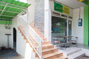 a restaurant with stairs leading to a table and chairs at RedDoorz near Banyuwangi Baru Station in Ketapang +7 photos