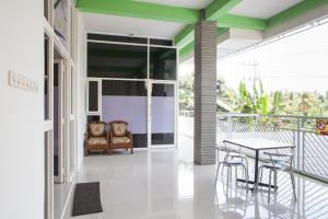 a room with a table and chairs on a balcony at RedDoorz near Banyuwangi Baru Station in Ketapang