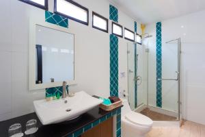 un bagno con lavandino, wc e doccia di Phi Phi Long Beach Resort & Villa a Phi Phi Don