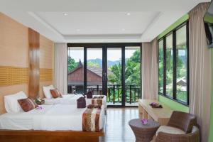 una camera d'albergo con due letti e una grande finestra di Phi Phi Long Beach Resort & Villa a Phi Phi Don Altre 26 foto