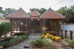a wooden gazebo in a garden at RedDoorz near Baluran National Park in Pandean