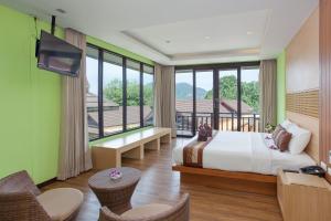 a hotel room with a bed and a large window at Phi Phi Long Beach Resort & Villa-SHA Extra Plus in Phi Phi Don