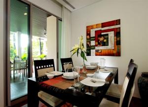 a dining room with a black table and chairs at Kata Gardens 2 bedroom near beach in Kata Beach