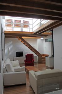 sala de estar con sofá y silla roja en Apartamentos Coronado, en Málaga