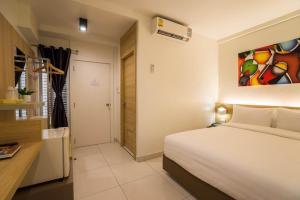 a bedroom with a bed and a painting on the wall at Bedtime Pattaya in Pattaya