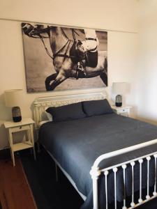 a bedroom with a bed with a horse painting on the wall at The Bower Mudgee in Mudgee