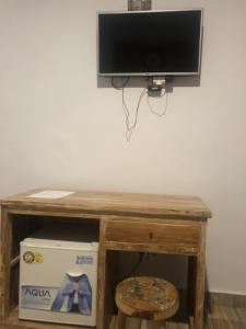 einen TV auf einem Holztisch in der Unterkunft Cantika Guest House in Uluwatu