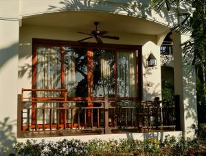 a house with a balcony with a fan at Villa Albizia in Chiang Mai in Doi Saket