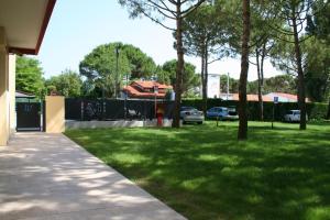 a grassy area with trees and a sidewalk at Appartamenti Vanin in Cavallino-Treporti