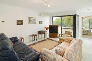 a living room with a couch and a tv at Bayside Beauty in Busselton