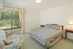 a bedroom with a bed and a couch and a window at Bayside Beauty in Busselton