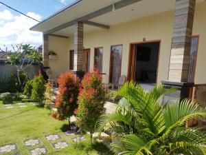 a house with a garden in front of it at Cantika Guest House in Uluwatu