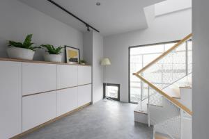 ein Wohnzimmer mit weißen Schränken und einer Treppe in der Unterkunft H suite Go in Changhua