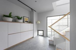 a living room with white cabinets and a staircase at H suite Go in Changhua City