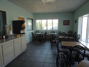 un restaurante con mesas y sillas en una habitación con ventanas en Atlantic Inn, en Millsboro
