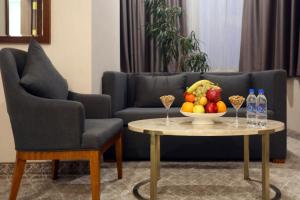 a living room with a couch and a table with a bowl of fruit at Parliament Palace Hotel in Khujand