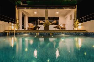 a swimming pool at night with chairs and tables at Lavonca Boutique Hotel in Colombo