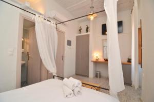 a bedroom with a bed with white sheets and curtains at Sophia Areopoli Guesthouse in Areopolis