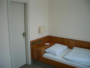 a small bedroom with a bed and a night stand at Haus-Maria in Bad Salzschlirf