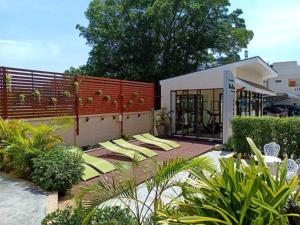 a garden with yellow chairs in front of a building at Mei Zhou Phuket Hotel - SHA Plus in Phuket Town