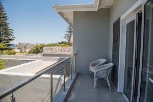 a balcony of a house with two chairs at The Whale on Main B&B in Hermanus