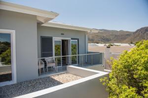 a house with a balcony with a view of the mountains at The Whale on Main B&B in Hermanus