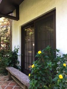 eine Eingangstür eines Hauses mit einer Bank und Blumen in der Unterkunft La Famille Canyon Woods Tagaytay in Balibaguhan