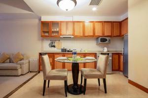 a kitchen with a table and chairs in a room at Dalian Asia Pacific Service Apartment (Former Somerset Harbour Court Dalian) in Dalian