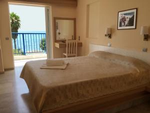 1 dormitorio con 1 cama grande y ventana grande en Hotel Golden Sun, en Finikounta