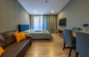 ein Hotelzimmer mit einem Bett und einem Sofa in der Unterkunft The Valley Bakuriani in Bakuriani