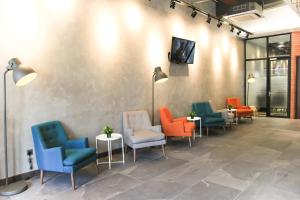 a waiting room with colorful chairs and tables at Amigo Hotel in Miri