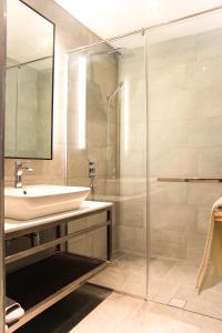 W łazience znajduje się umywalka i przeszklony prysznic. w obiekcie Amigo Hotel w mieście Miri