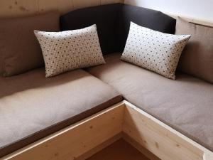 a brown couch with two pillows on it at Aussermairhof in Campo Tures