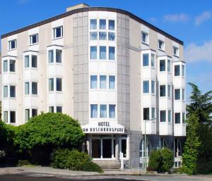 Un gran edificio blanco con un cartel en él. en Hotel am Buschkrugpark, en Berlín